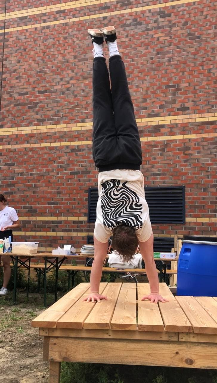 Micha macht einen Handstand und trägt das T-Shirt